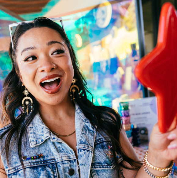 Three women standing next to each other trying to catch falling Lumify products